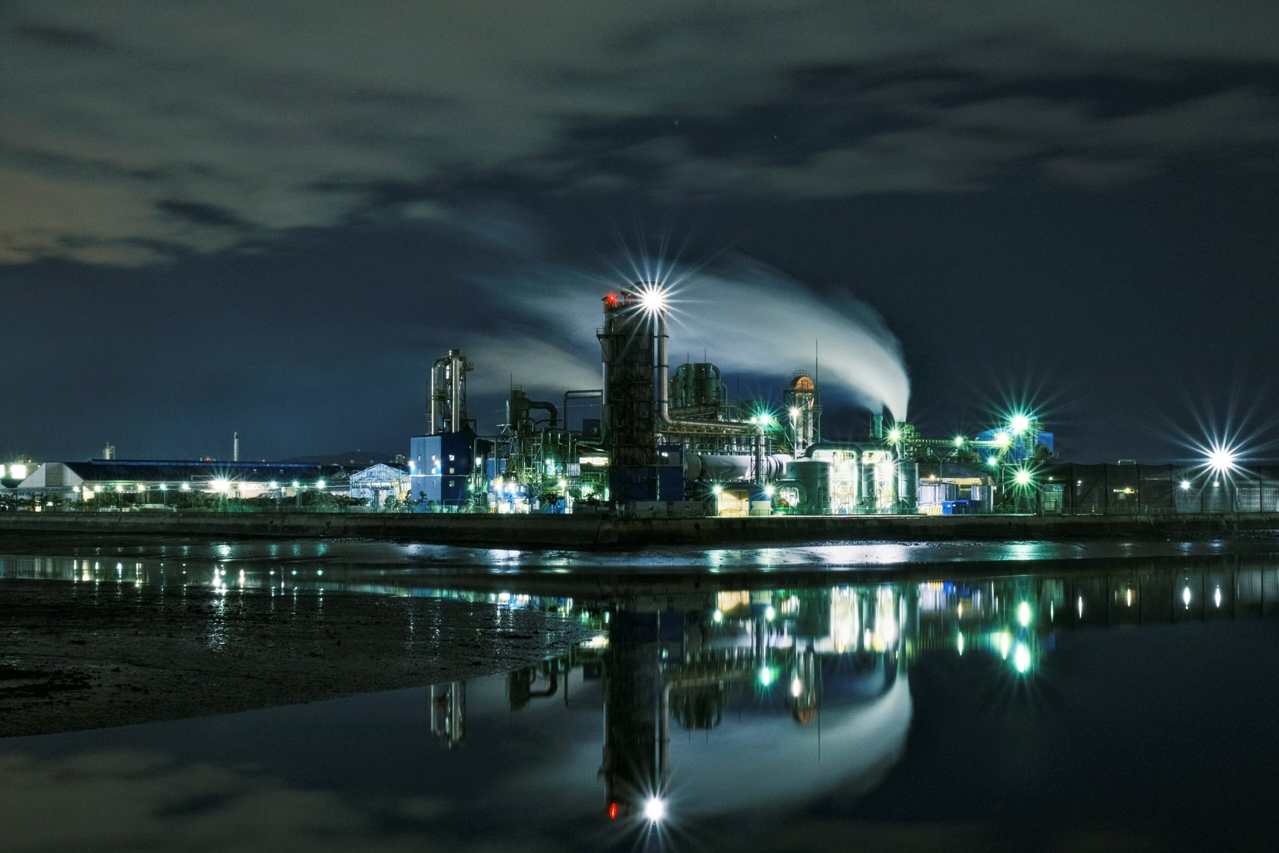 Industrial plant facility at night representing reliability services for critical operations